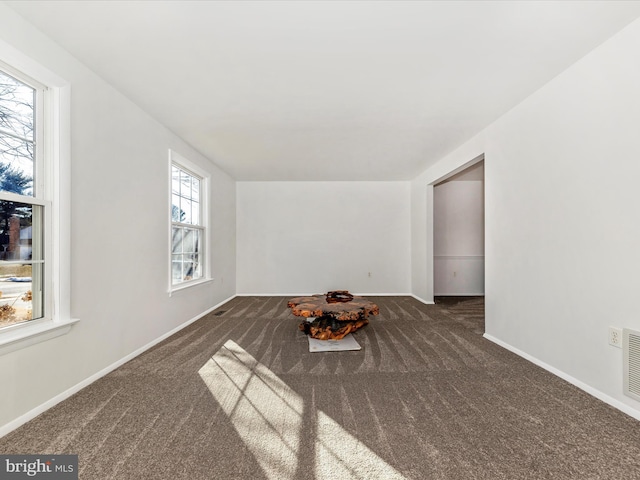 unfurnished room with dark carpet