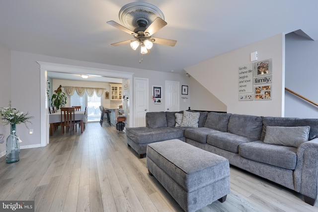 living room with ceiling fan and light hardwood / wood-style flooring