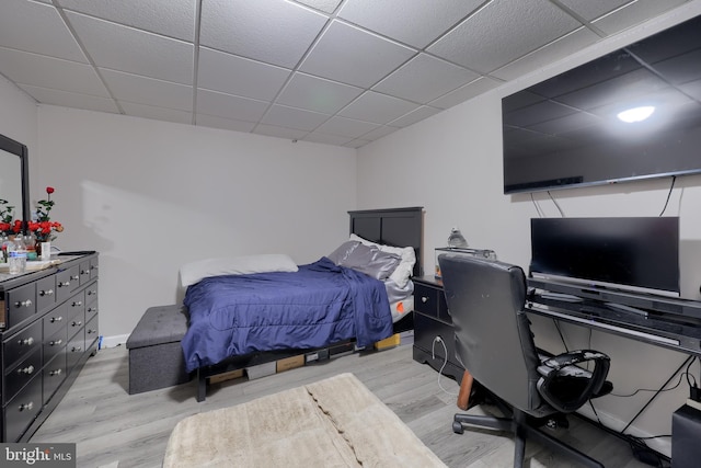 bedroom featuring a drop ceiling and light hardwood / wood-style floors