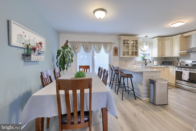 dining room featuring sink and light wood-type flooring