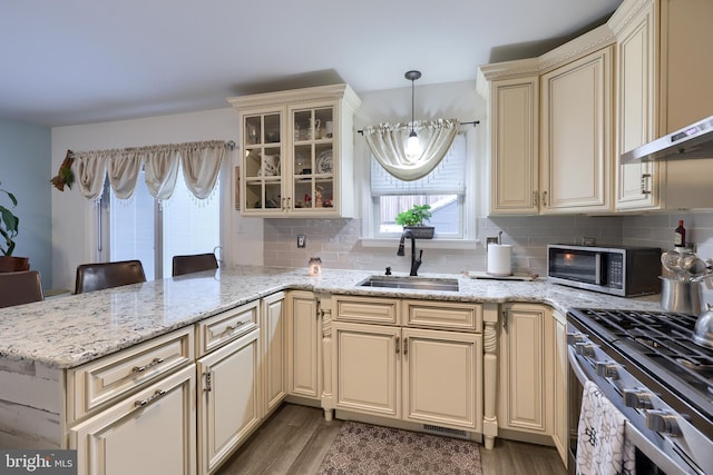 kitchen featuring cream cabinets, a breakfast bar, sink, and pendant lighting