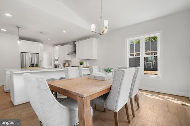 dining area with light wood-type flooring, an inviting chandelier, baseboards, and recessed lighting