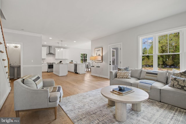 living area with light wood-style flooring, baseboards, crown molding, and recessed lighting