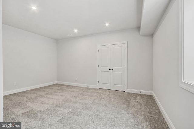 carpeted spare room featuring baseboards and recessed lighting