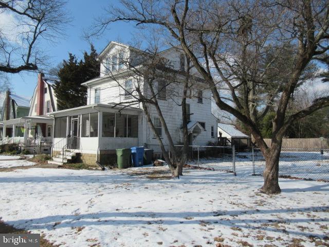 snow covered property featuring a sunroom