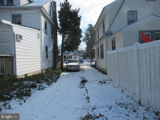 yard covered in snow featuring a wall mounted AC