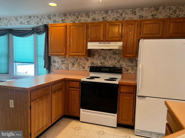 kitchen with white refrigerator, kitchen peninsula, light tile patterned flooring, and electric range oven