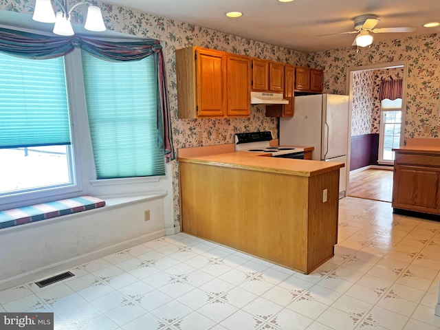 kitchen featuring ceiling fan, pendant lighting, white appliances, and kitchen peninsula