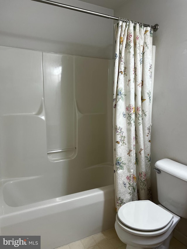 bathroom featuring shower / bathtub combination with curtain and toilet