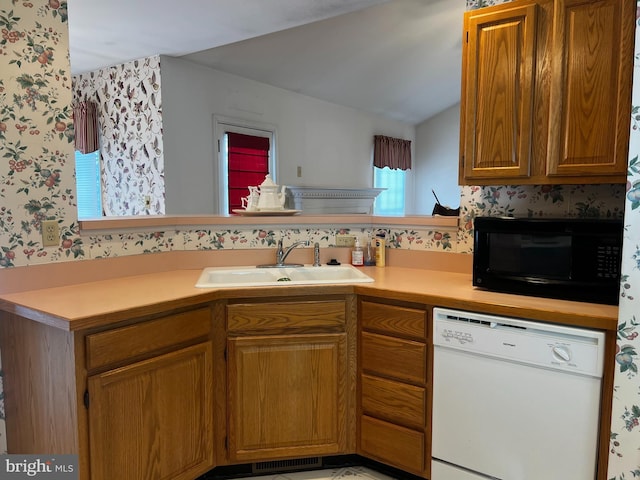 kitchen featuring sink, white dishwasher, and kitchen peninsula