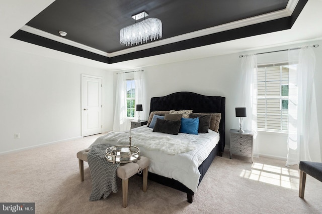 bedroom with ornamental molding, carpet floors, and a tray ceiling