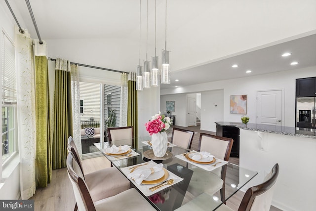 dining space featuring lofted ceiling and light wood-type flooring