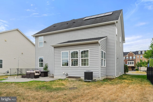 rear view of house with a yard, an outdoor hangout area, a patio, and solar panels