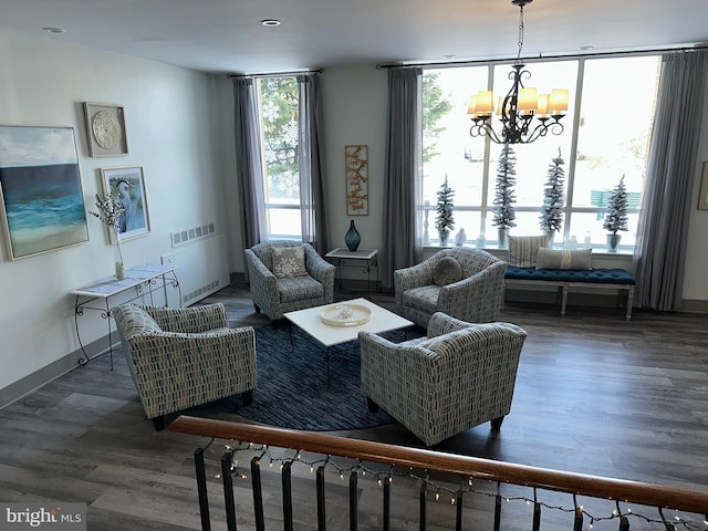 living room with dark hardwood / wood-style flooring, a notable chandelier, and floor to ceiling windows