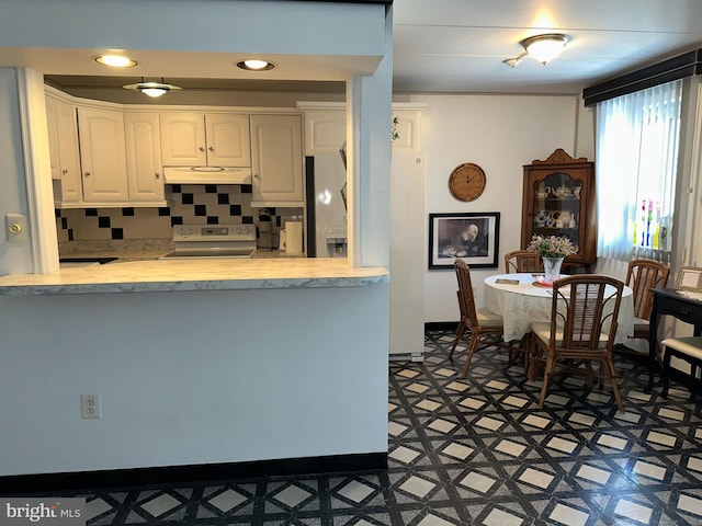 kitchen with white cabinetry, range with electric stovetop, tasteful backsplash, and fridge with ice dispenser