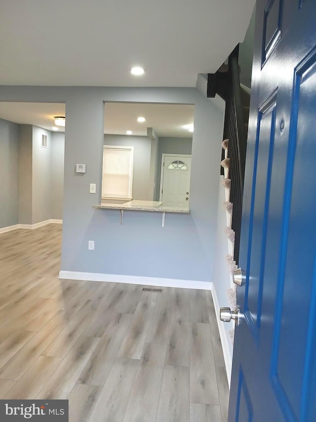 basement with light hardwood / wood-style flooring