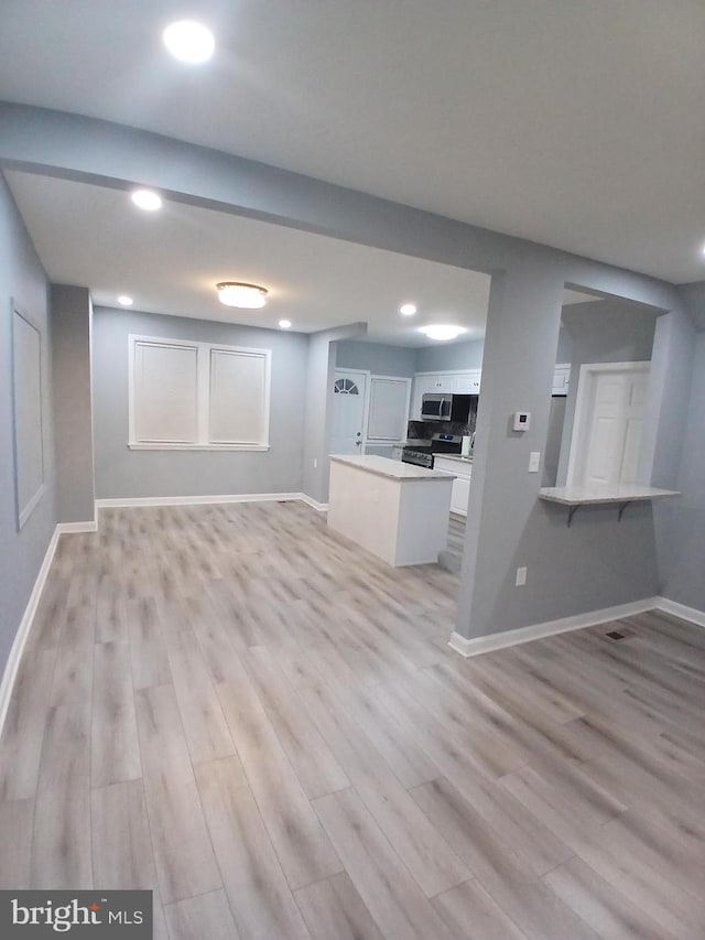 unfurnished living room with light wood-style floors, baseboards, and recessed lighting