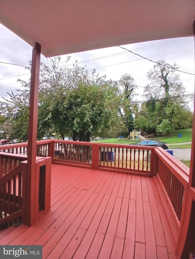 wooden terrace featuring a playground