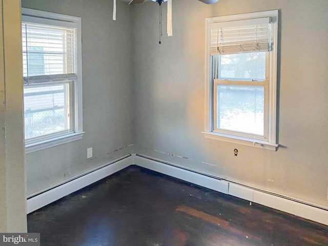 unfurnished room with a baseboard heating unit