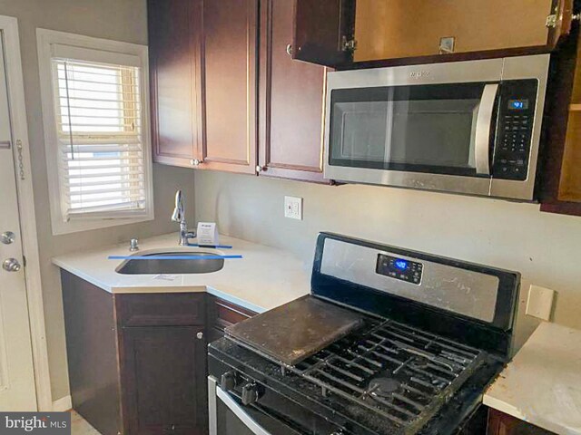 kitchen featuring dark brown cabinetry, appliances with stainless steel finishes, and sink