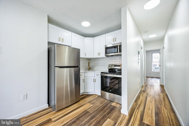 kitchen with white cabinetry, backsplash, and appliances with stainless steel finishes