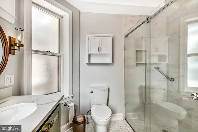 bathroom featuring toilet, a shower stall, baseboards, and vanity