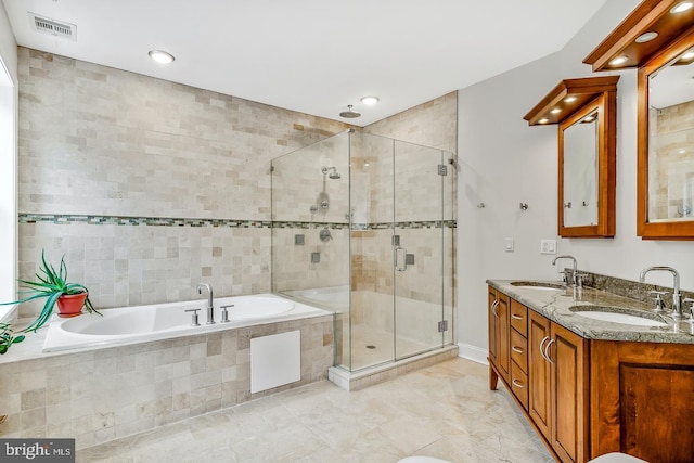 bathroom with visible vents, a sink, a shower stall, and a bath