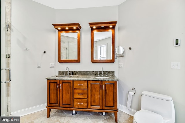 bathroom with vanity, a shower with door, and toilet