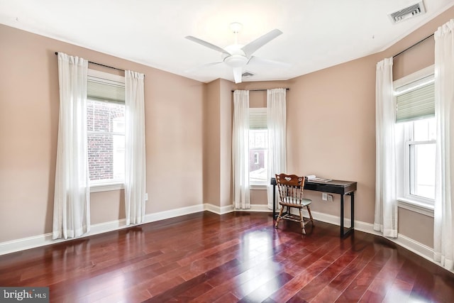 office featuring dark wood-style floors, baseboards, visible vents, and a ceiling fan