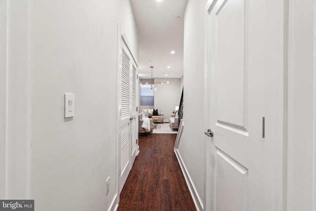 hallway featuring a notable chandelier and dark hardwood / wood-style flooring