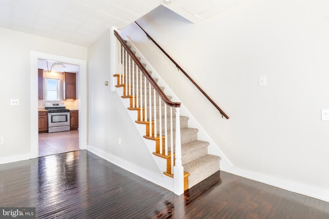 staircase with hardwood / wood-style flooring