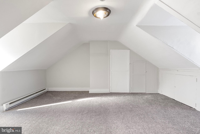 additional living space with baseboard heating, lofted ceiling, and carpet flooring