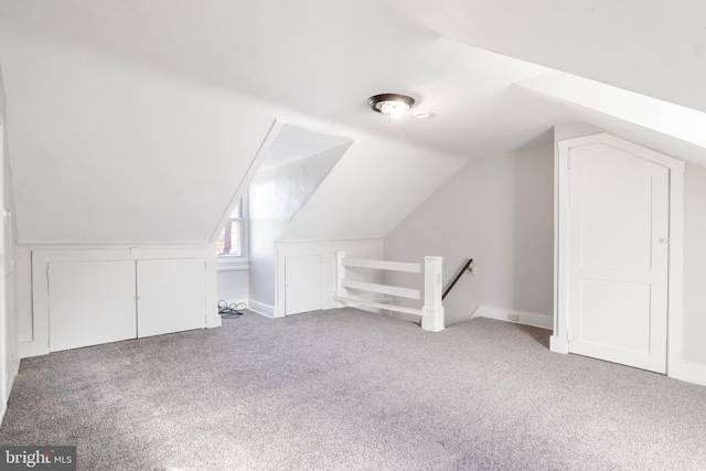 bonus room with lofted ceiling and carpet flooring