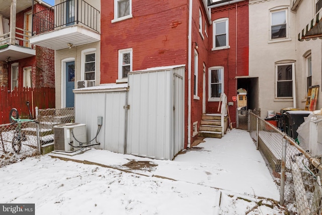 view of snow covered exterior featuring cooling unit