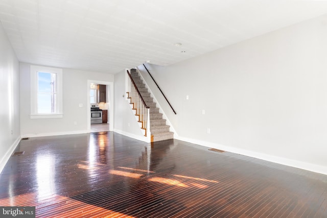 unfurnished living room with dark wood-type flooring