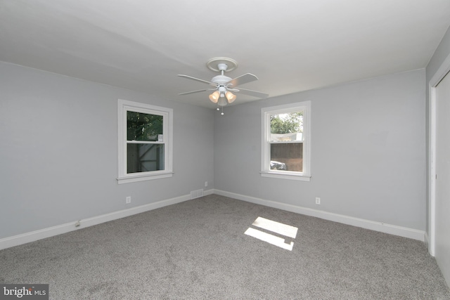 carpeted spare room featuring ceiling fan