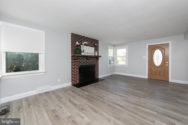 unfurnished living room with a fireplace and light hardwood / wood-style flooring