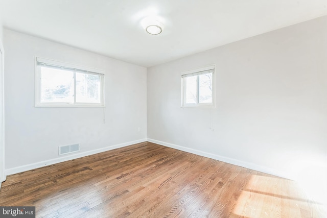 empty room featuring plenty of natural light and hardwood / wood-style floors