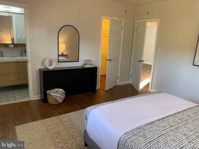 bedroom with dark hardwood / wood-style flooring and connected bathroom