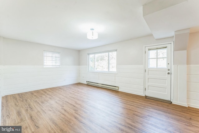 entryway featuring baseboard heating, a healthy amount of sunlight, and light wood-type flooring