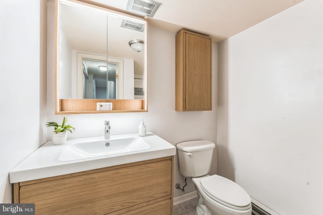 bathroom with vanity, toilet, and a baseboard heating unit