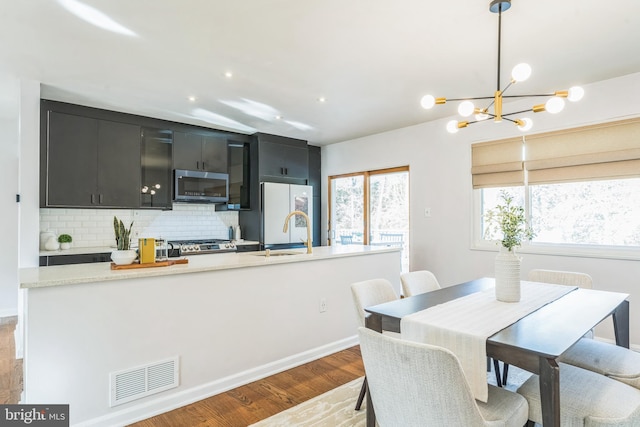 dining room with an inviting chandelier, light hardwood / wood-style floors, and sink