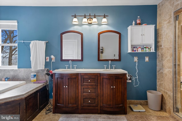 bathroom featuring a tub, tile patterned flooring, a sink, and double vanity