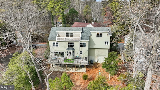 rear view of property featuring central AC, a shingled roof, and a wooden deck