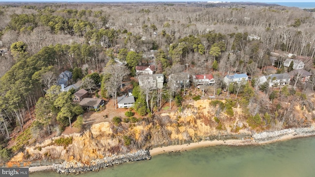 aerial view with a water view and a wooded view