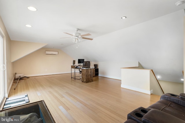 interior space featuring a wall unit AC, recessed lighting, baseboards, vaulted ceiling, and light wood-type flooring