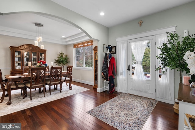 entryway with arched walkways, a chandelier, recessed lighting, dark wood-style flooring, and baseboards