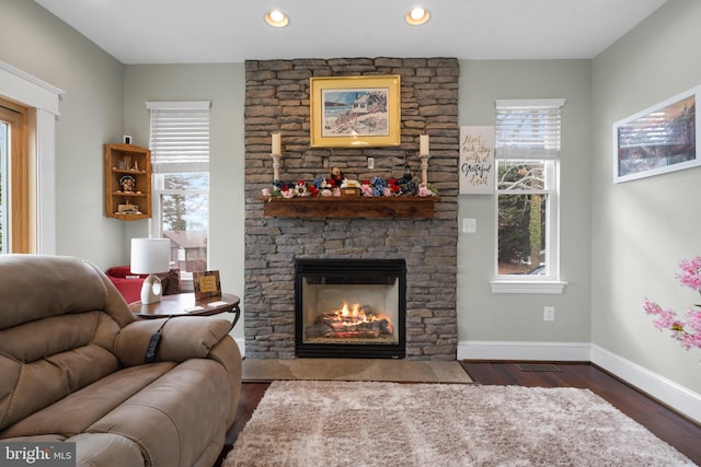 living area with dark wood-type flooring, recessed lighting, a fireplace, and baseboards