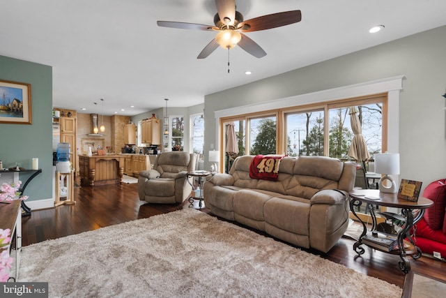 living area with a healthy amount of sunlight, baseboards, dark wood-type flooring, and recessed lighting