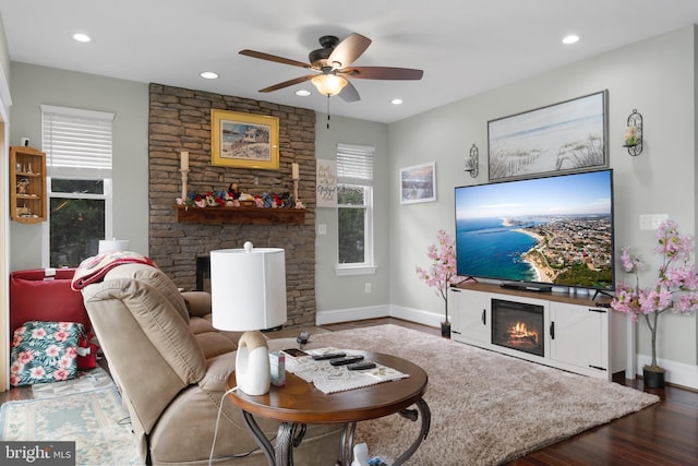 living area with a lit fireplace, wood finished floors, and recessed lighting